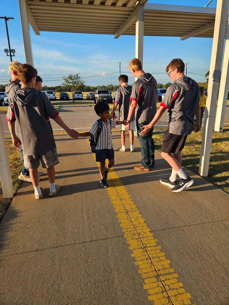 High school students welcoming elementary students to school