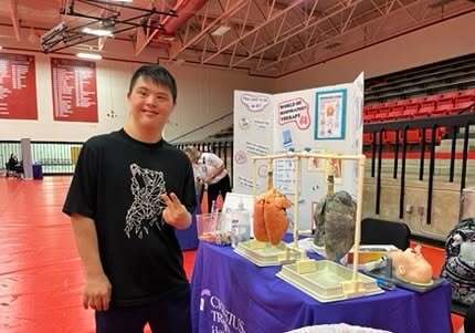 student at a table at a high school event