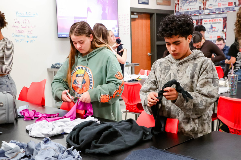 students cutting up clothing
