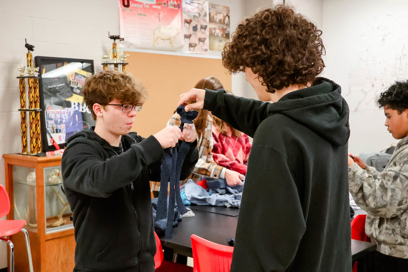 students braiding a dog toy