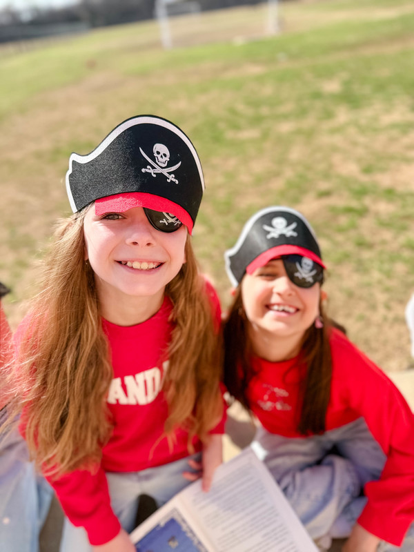 students dressed as pirates reading outside