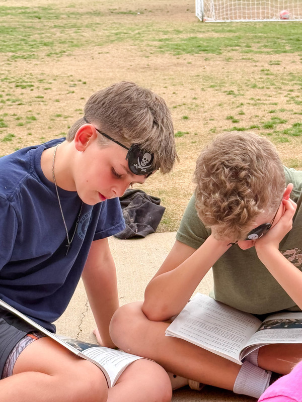 students dressed as pirates reading outside