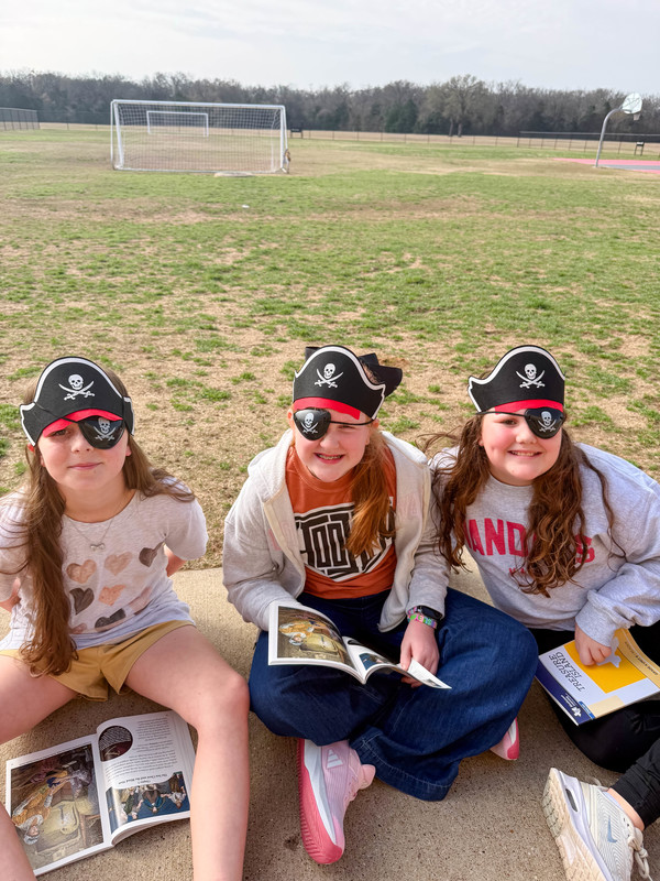 students dressed as pirates reading outside