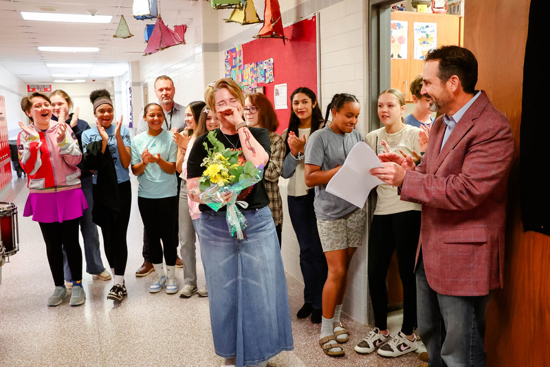 mrs. barker surprised as teacher of the year holds flowers and cries