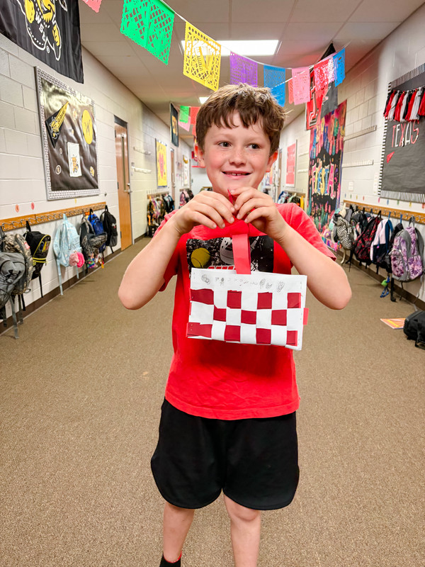 student holds up basket creation