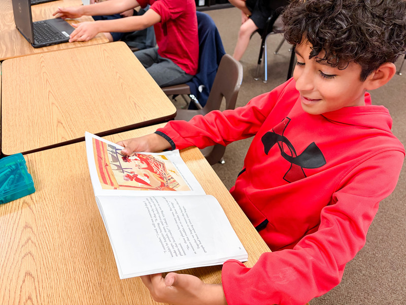 student reads at desk
