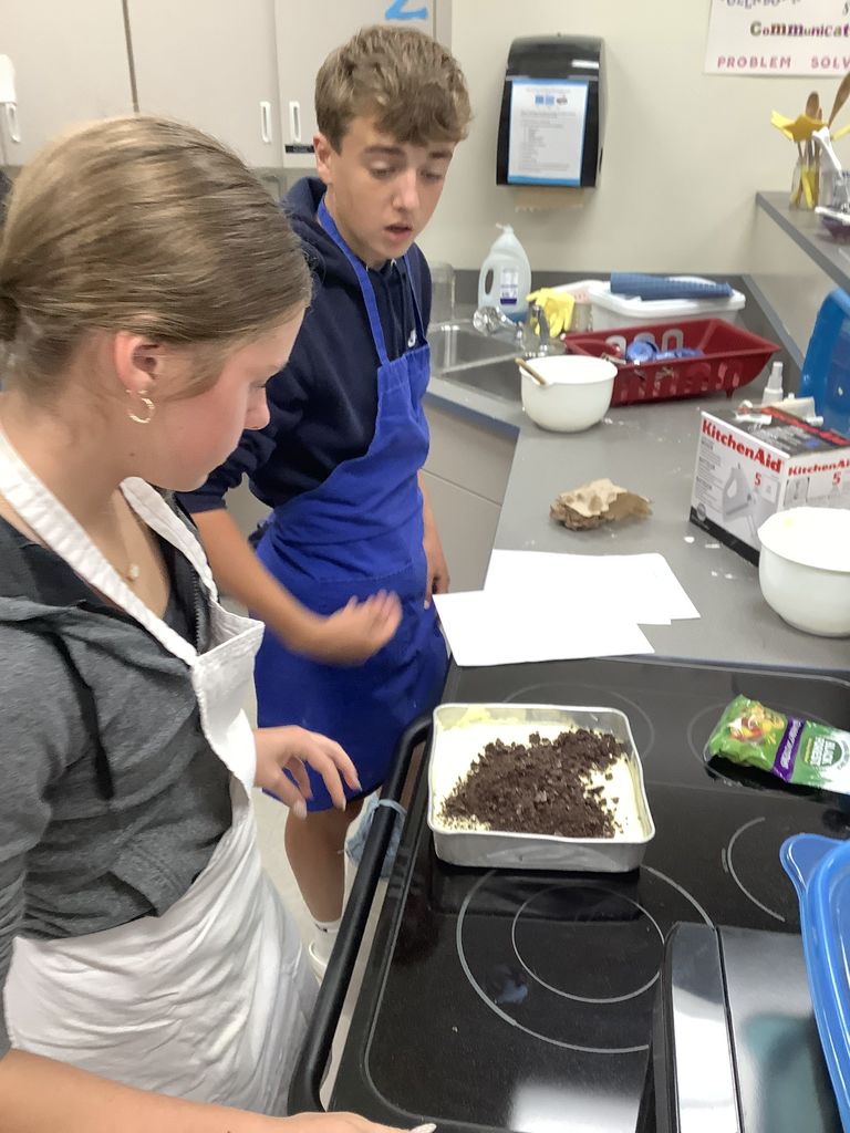 Two students looking over their dirt cake.