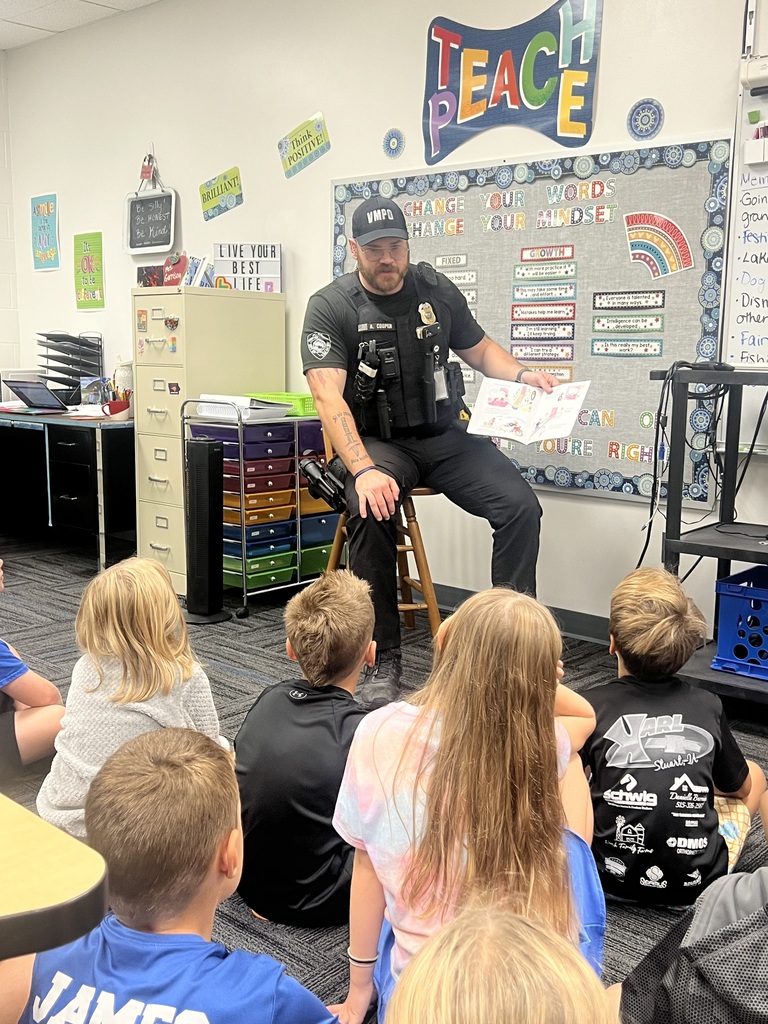 Officer Cooper reading a book to students in Mrs. Garrison’s 3rd grade class.