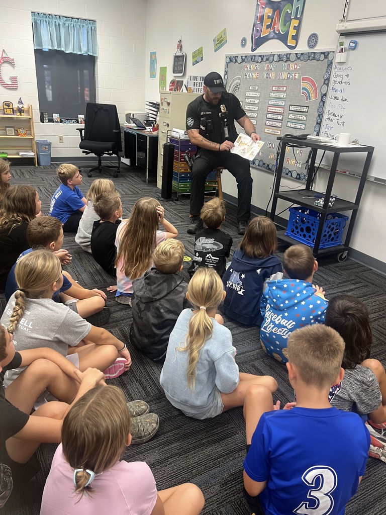 Officer Cooper reading a book to students in Mrs. Garrison’s 3rd grade class.