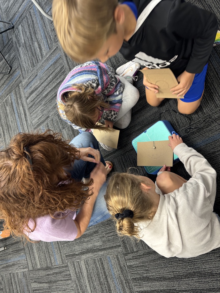 Four students crowed around the Chompsaw.