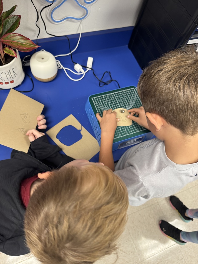 Two boy students using the Chompsaw, the view of the photo is from above their heads.