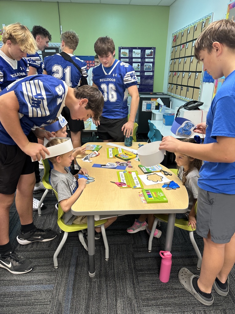 Football students working with their elementary buddies.