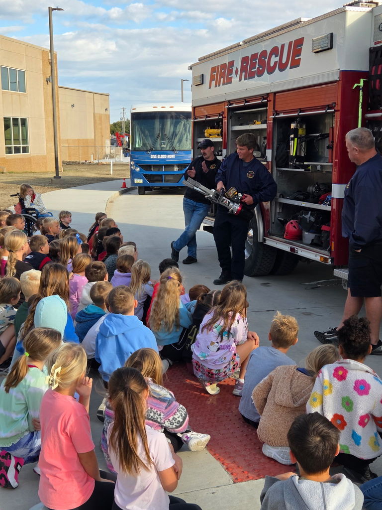 Van Meter Fire Department showing a piece of equipment to a group of students.
