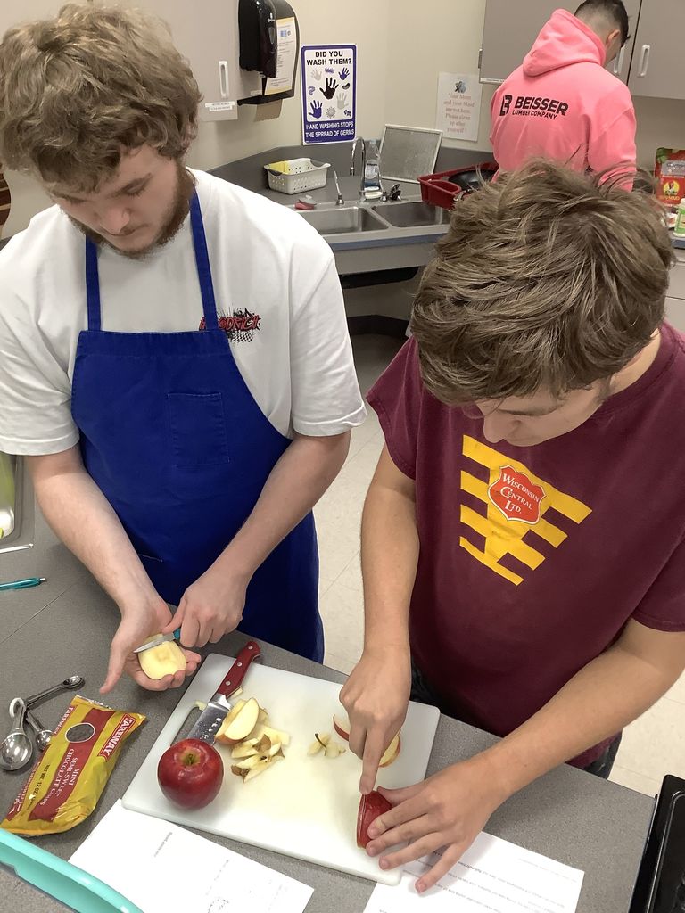 Two students coring and cutting apples.