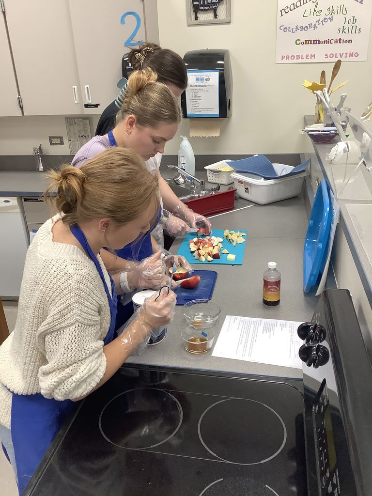 Three students making their apple dish.