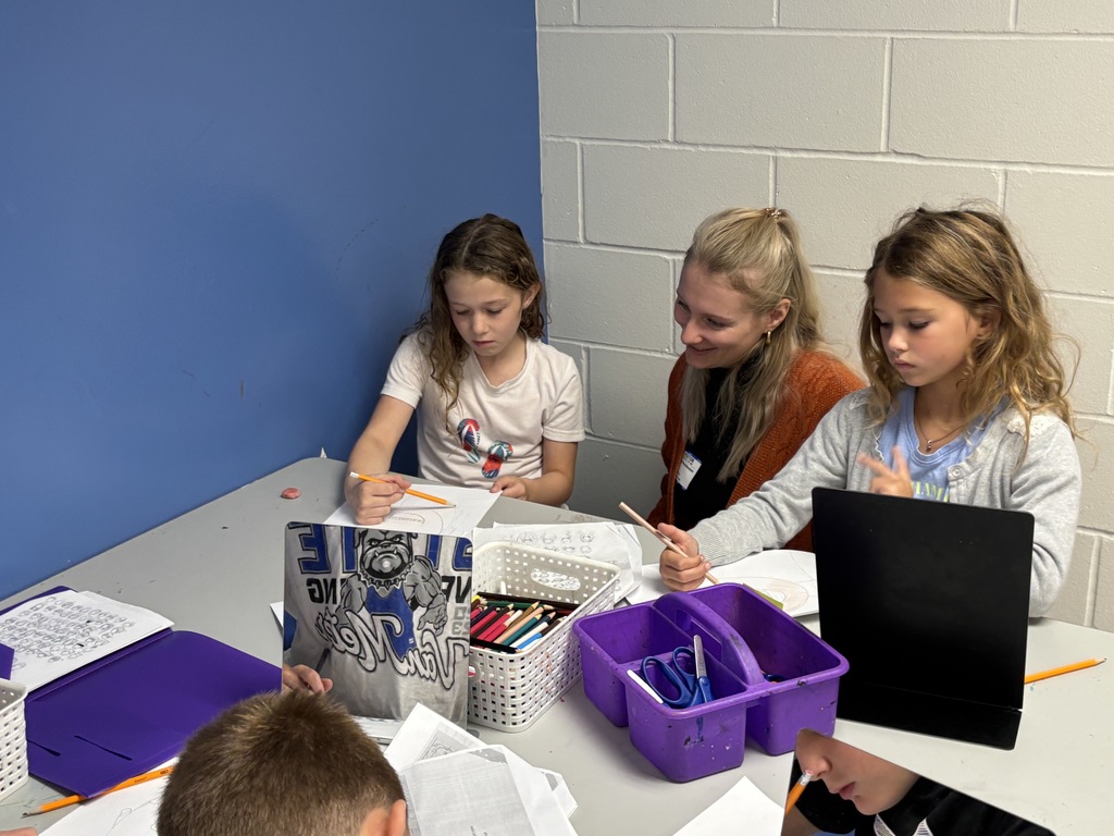 Guest speaker working with two students in the classroom