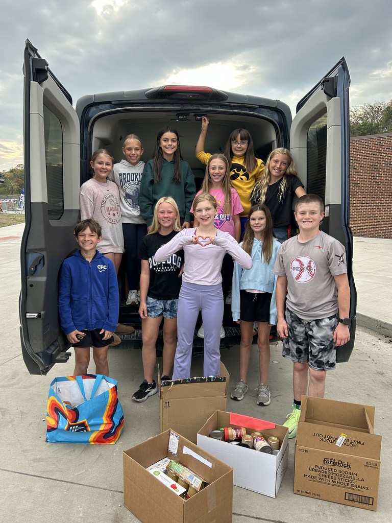 Students smiling by the donations.