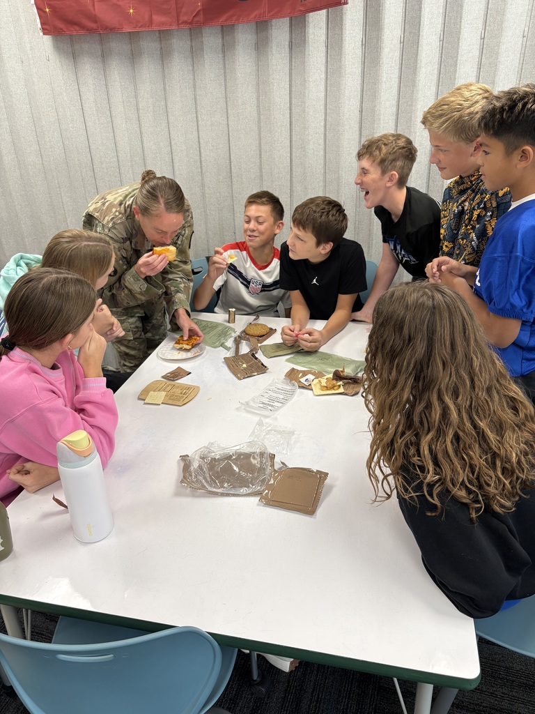 Debra smelling the food with a table of students