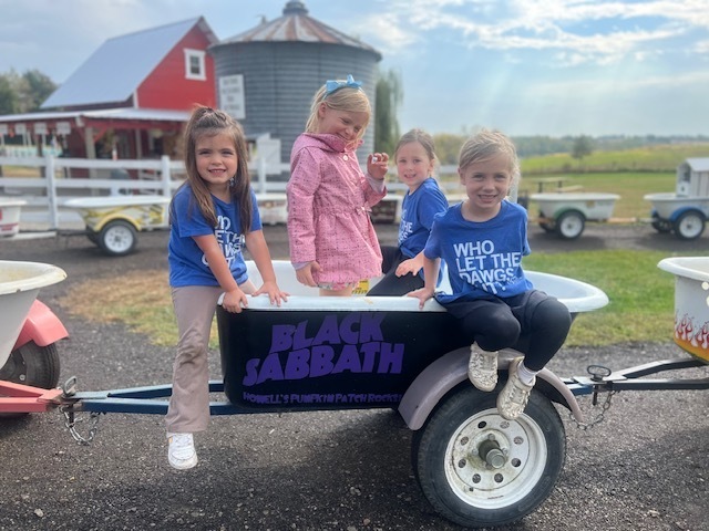 Four students on a ride with wheelbarrows.