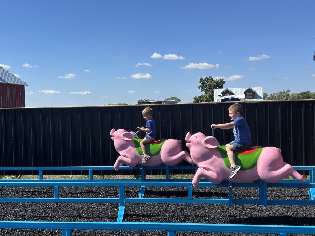 Two students on a ride with racing pigs.