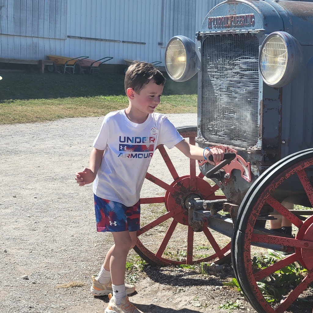 Students playing with the front of an old tractor