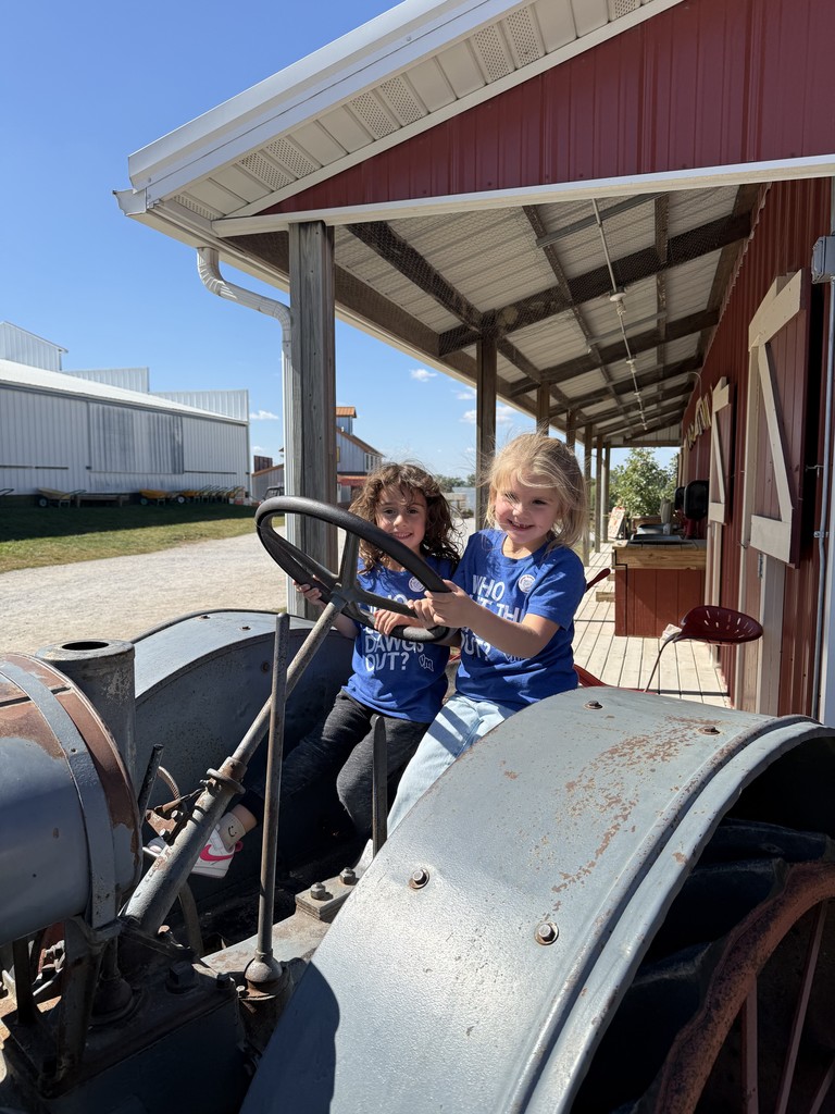 Two students enjoying playing drive the tractor