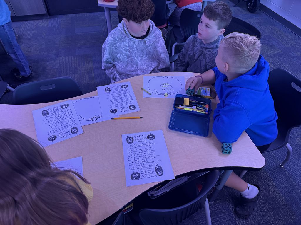 Three students playing the game and discussing.