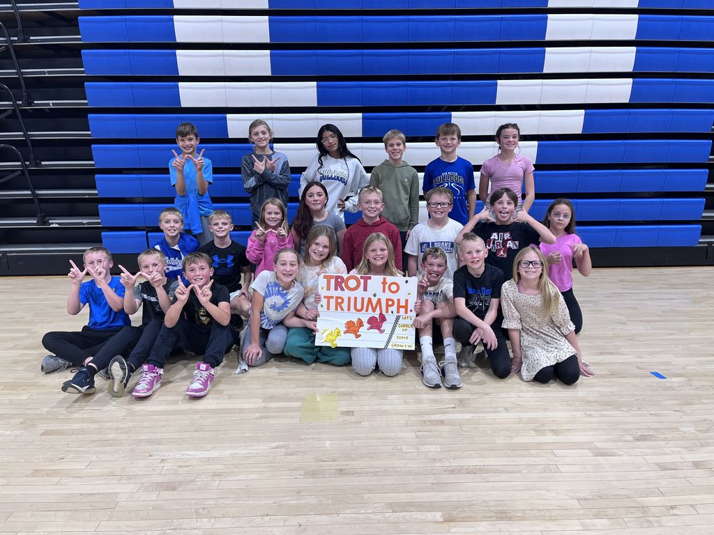 A class of our 5th graders posed for a picture withe the Trot to Triumph sign.