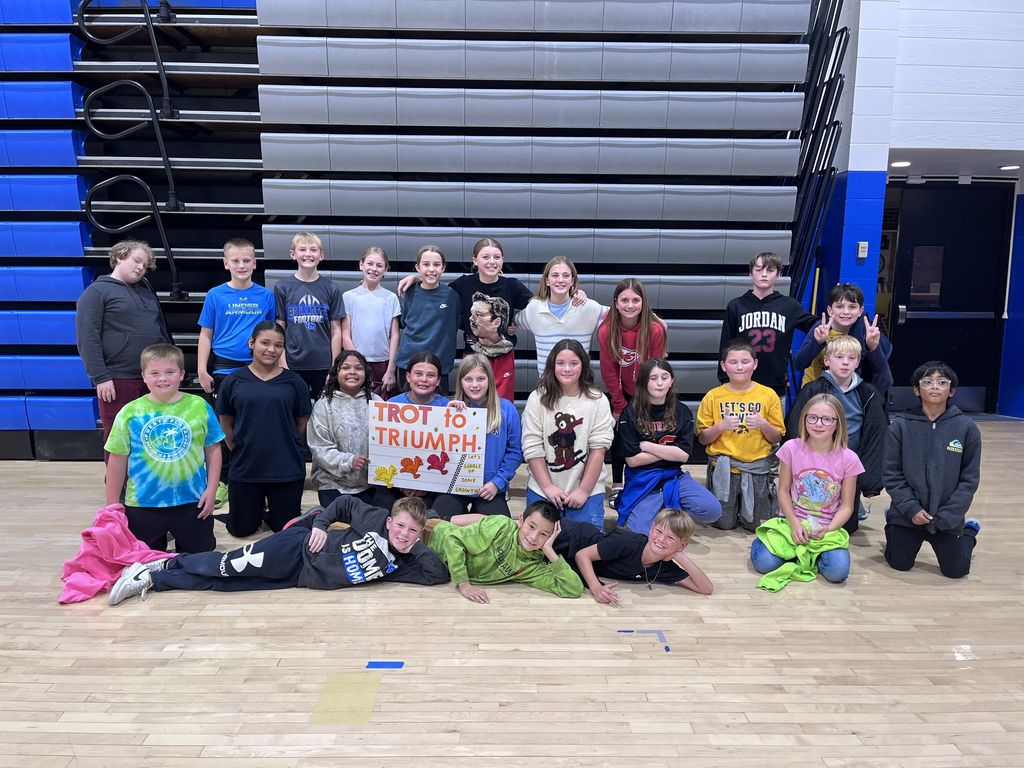 A class of our 5th graders posed for a picture withe the Trot to Triumph sign.