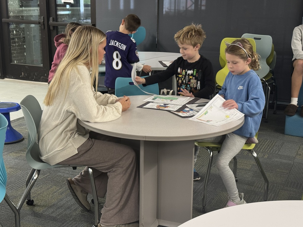 A high school student helping two second graders.