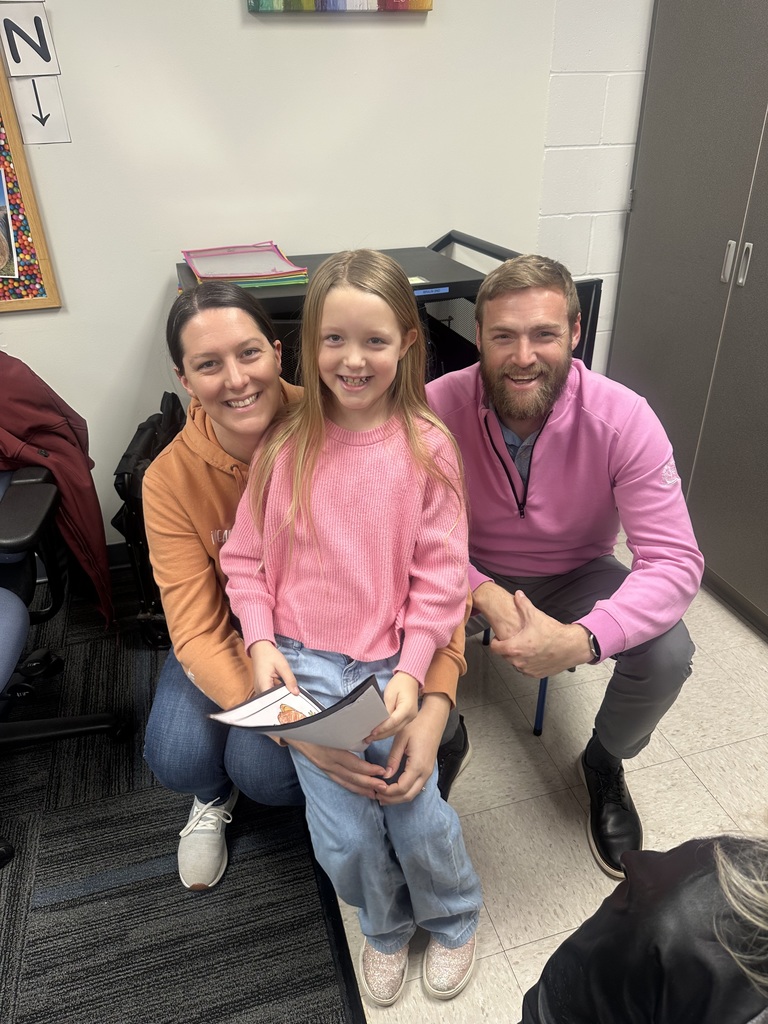 A student smiling with two of their family members