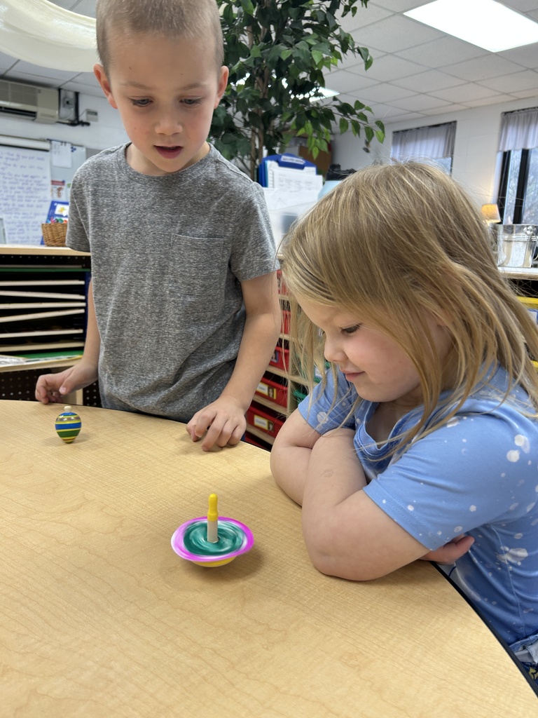 Two students playing with multiple spin toys.