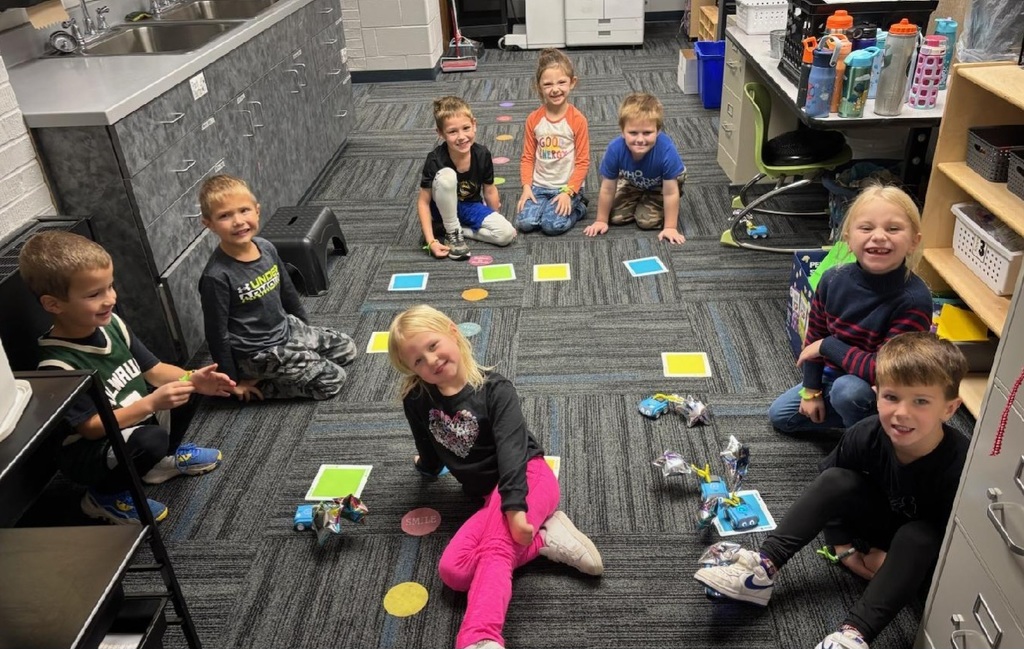 Students in a circle on the floor with their game!