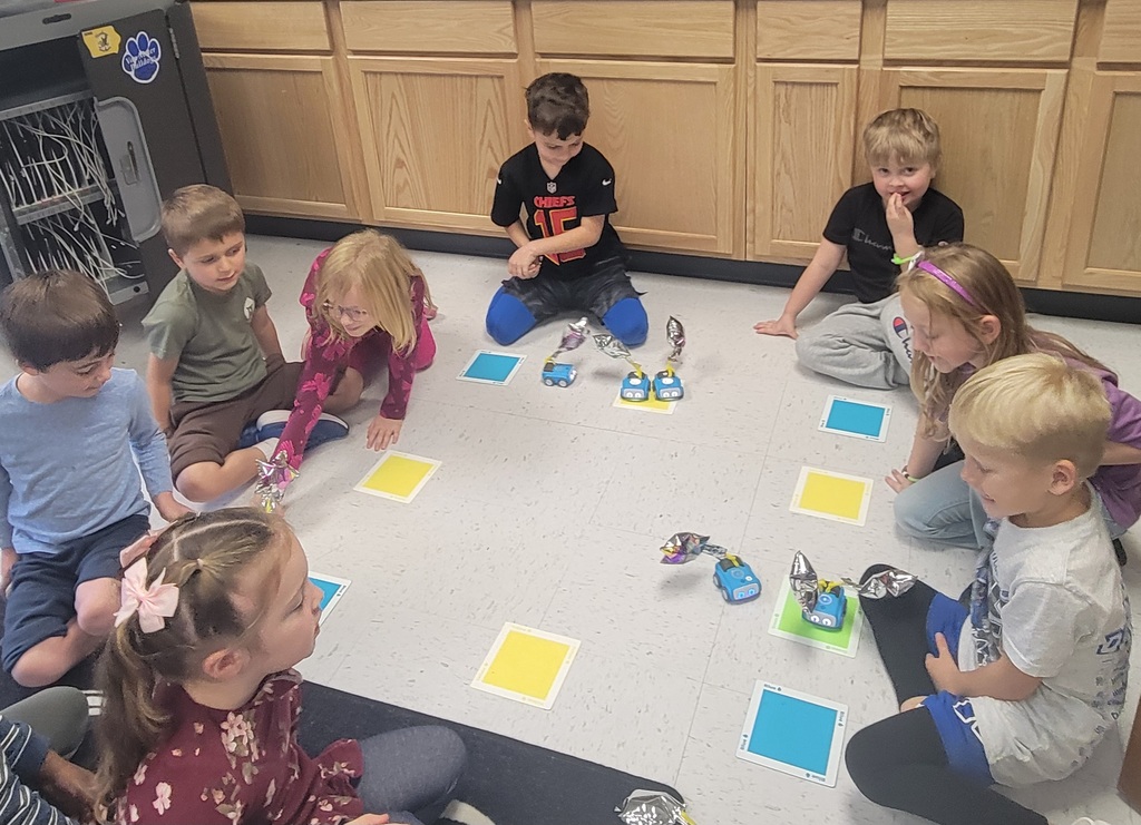 Students in a circle on the floor with their game.