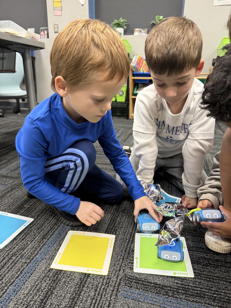 Two students with their card game on the floor.