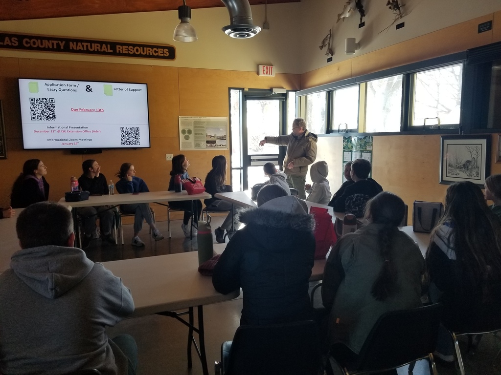 Students listening to the speaker while sitting at desks