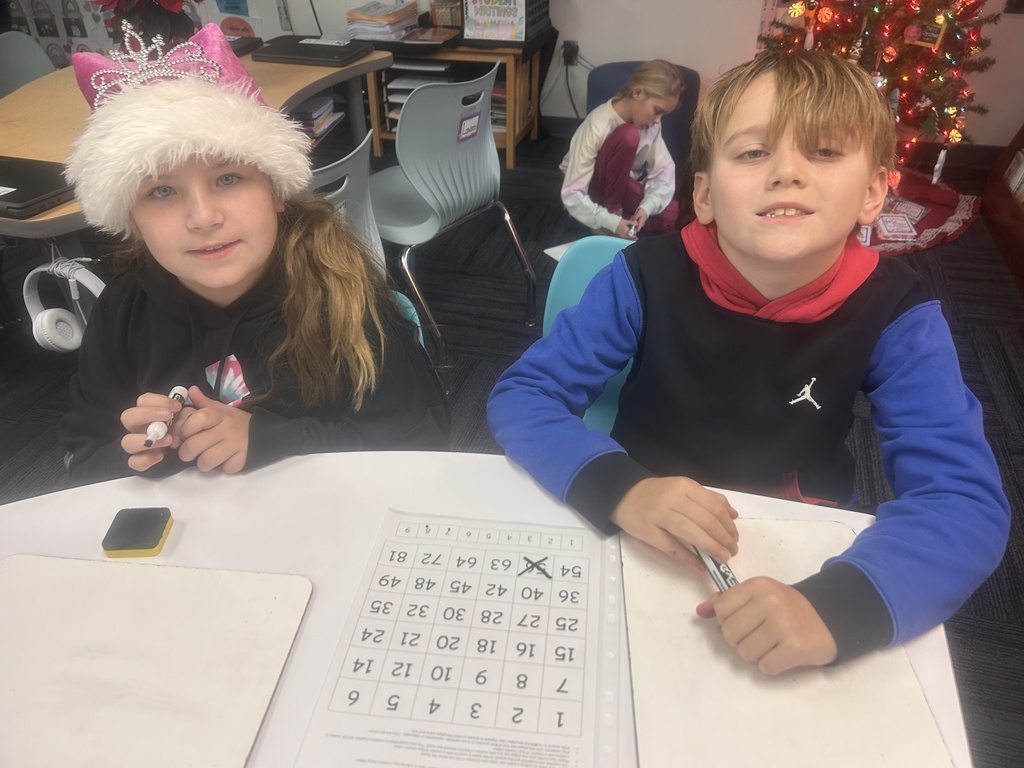 Two students smiling for the picture, one has a hat on