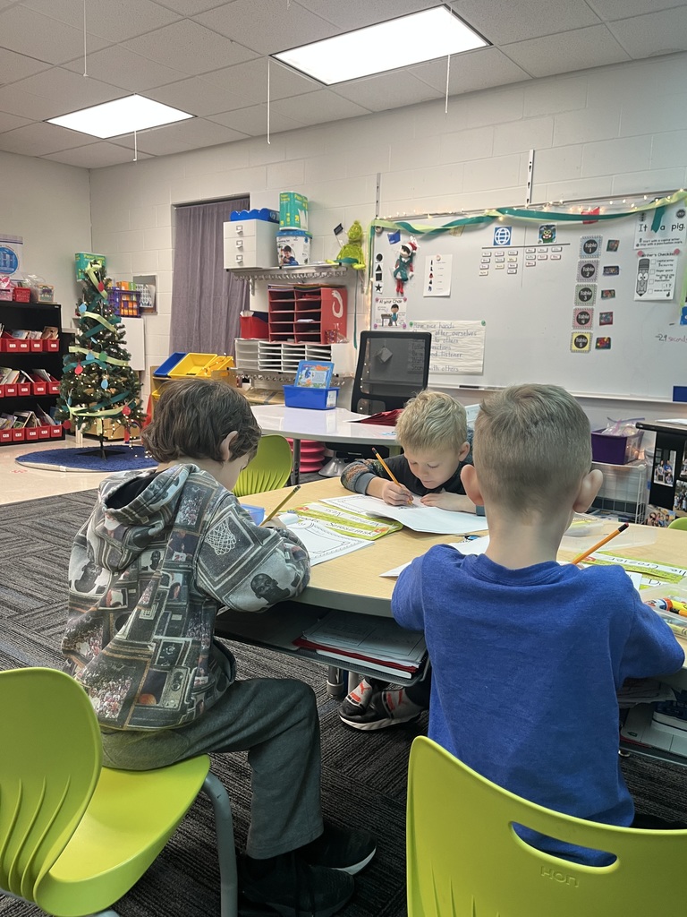 Three students writing in their Elf Adventures journals.