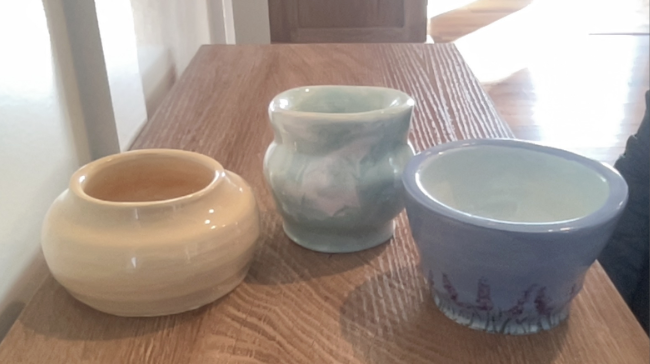 Three ceramic bowls, all different shapes and colors with shiny finishes.