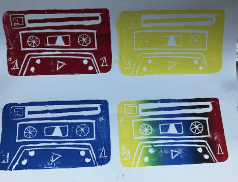 Four colorful cassette tape prints arranged in a 2x2 grid with red, yellow, blue, and a rainbow gradient design on a white background.