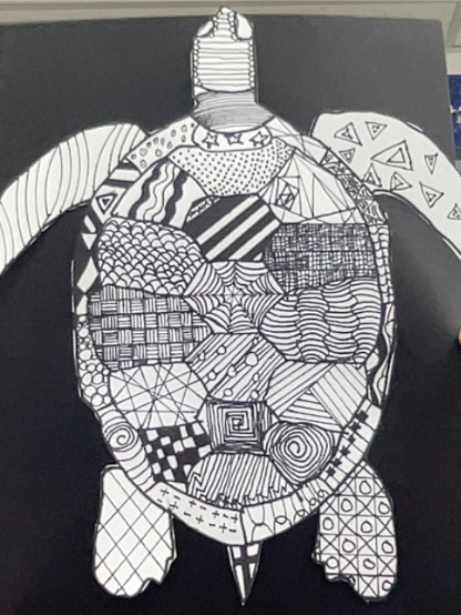 Black and white drawing of a turtle filled with various intricate geometric and abstract patterns on a dark background.
