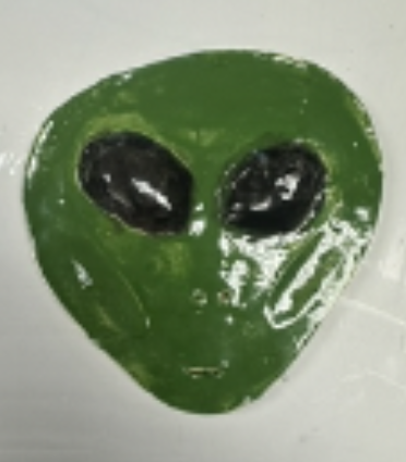 Glossy green alien face with large black eyes on a white background.