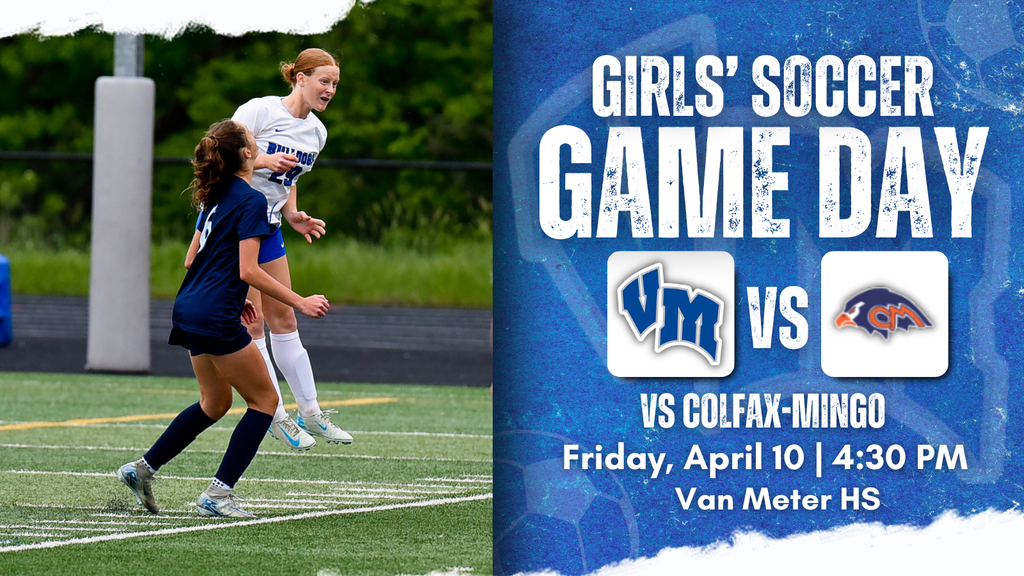 Two female soccer players competing mid-air during a match on a green field with trees in the background.