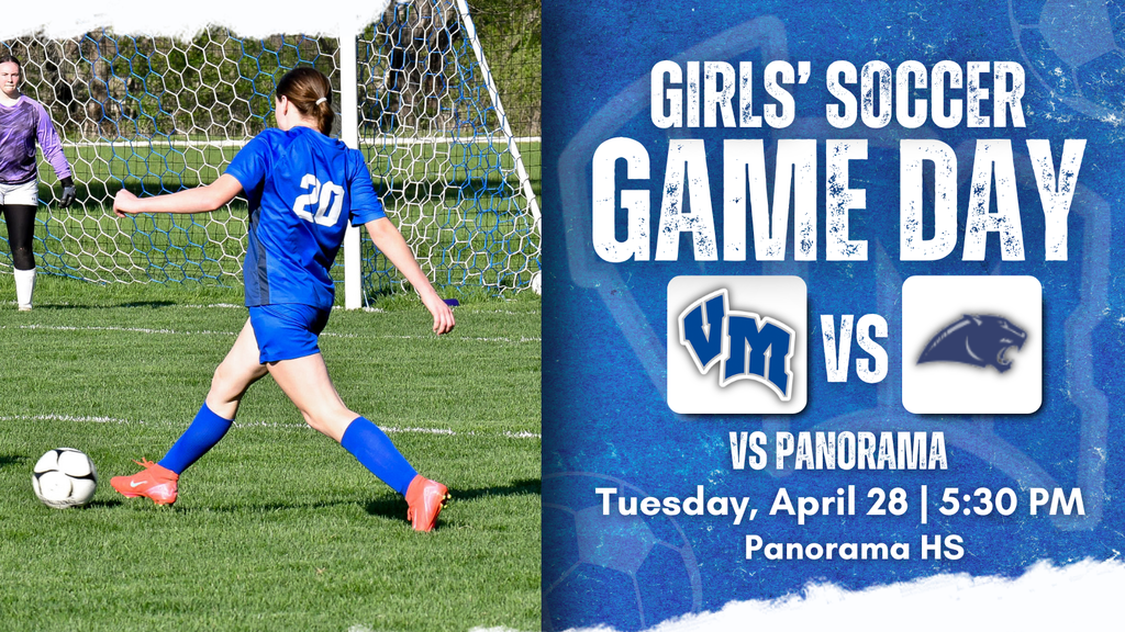 Girl in blue jersey number 20 kicking a soccer ball toward goal with goalie ready to defend on a sunny field.