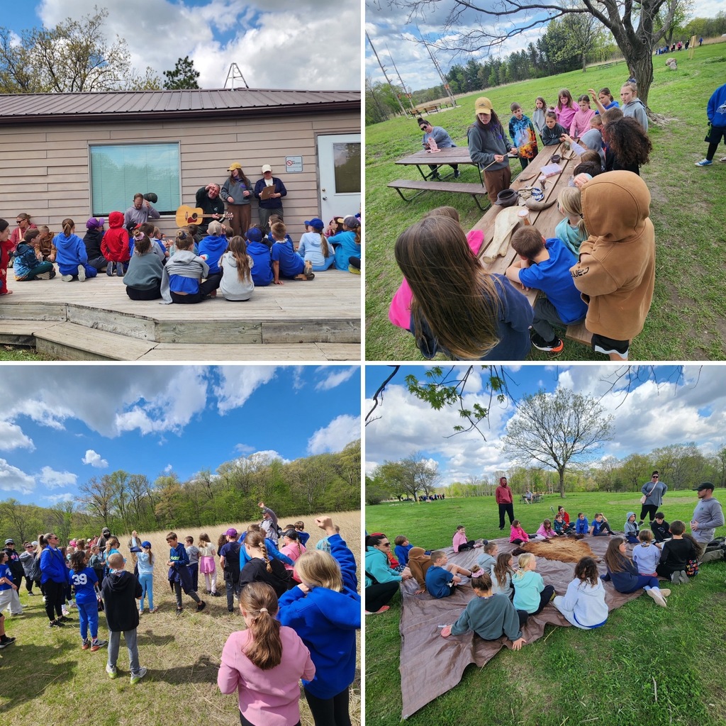 Children gathered outdoors listening to adults during an educational nature event on a sunny day.