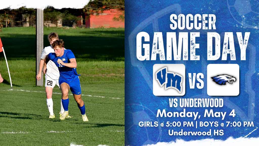 Two high school soccer players, one in blue and one in white, compete near the corner flag on a sunny field.