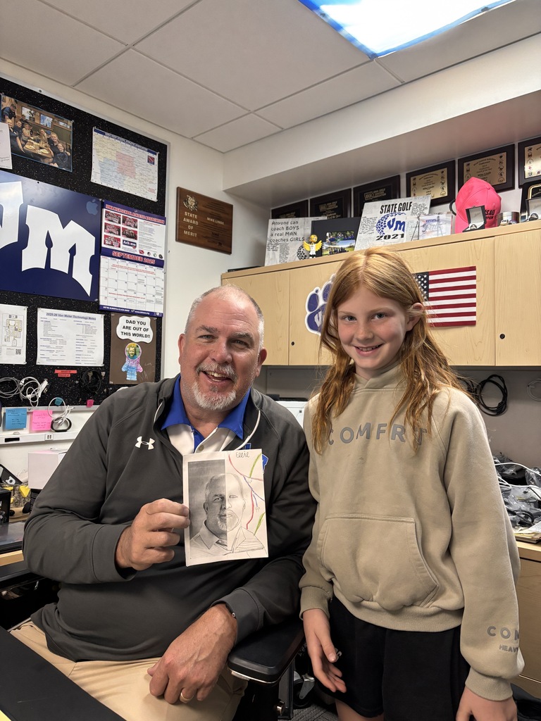 Student in gray hoodie stands beside smiling staff member holding a portrait drawing in office.