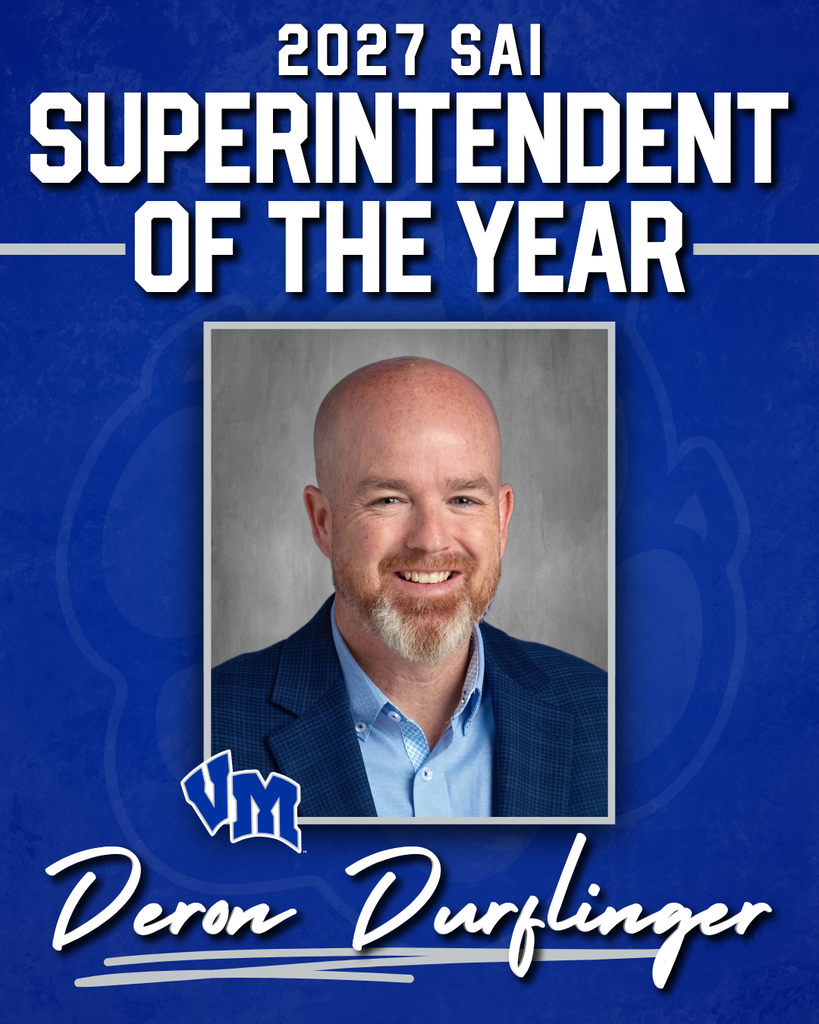 Portrait of Deron Durflinger, 2027 SAI Superintendent of the Year, smiling in a blue blazer and light blue shirt against a gray background.