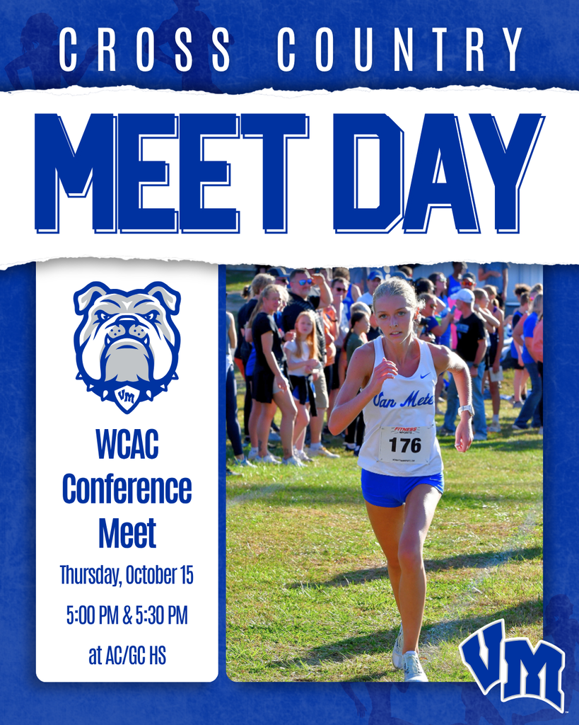 Female cross country runner in blue and white uniform competing at a meet with spectators in the background.