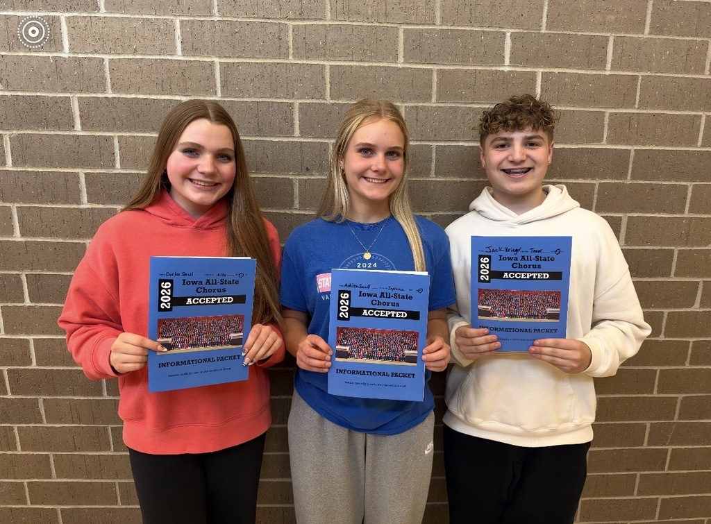 Three smiling high school students hold their 2026 Iowa All-State Chorus acceptance packets in front of a brick wall.